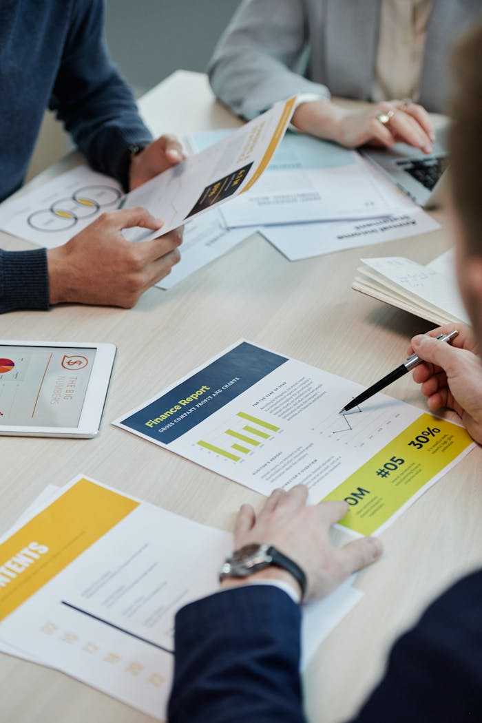services-01 Professionals working together in an office, analyzing financial reports and documents with focus on graphs and teamwork.